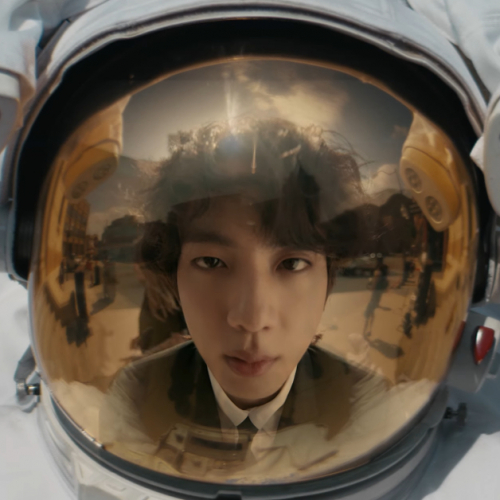 Jin (BTS) looking into a Spacesuit helmet and seeing his reflection