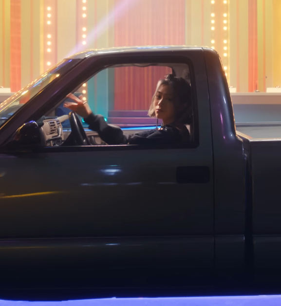 Image shows Ryujin sitting in a pickup truck while looking at the camera