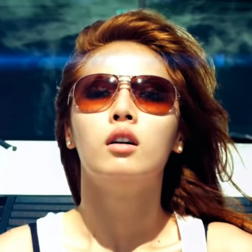 Image shows a Korean women wearing sunglasses and her hair flowing with the wind