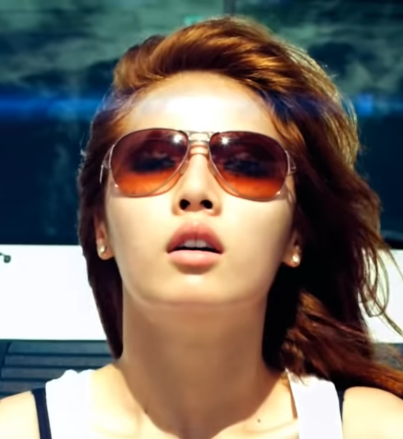 Image shows a Korean women wearing sunglasses and her hair flowing with the wind