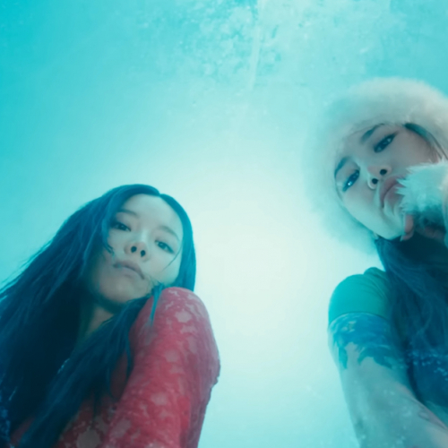 Image shows two Korean women looking down at the camera through ice