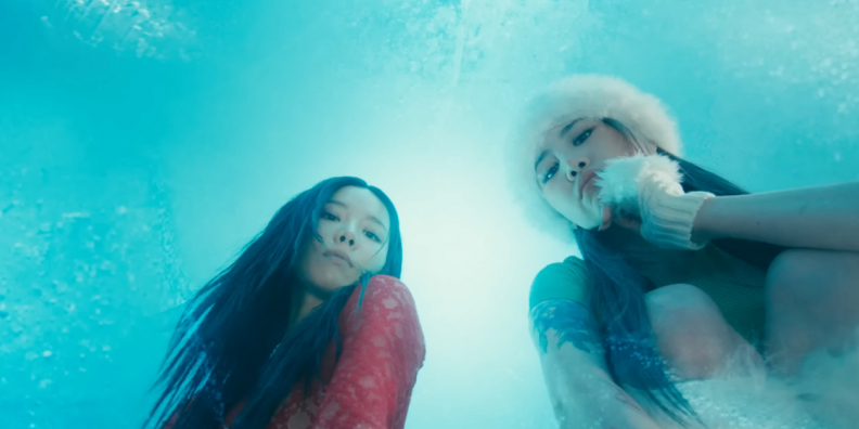 Image shows two Korean women looking down at the camera through ice