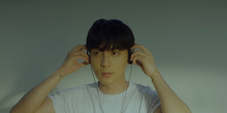 Image shows Roy Kim putting on headphones as he looks off camera