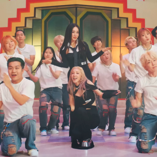 Uhm Jung Hwa and Sandara Park are posing in the middle with arms out, while surrounded by clapping backup dancers