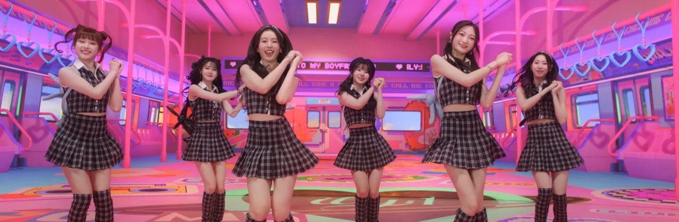 6 members of ILY:1 are dancing in a very large room that looks like a subway car.