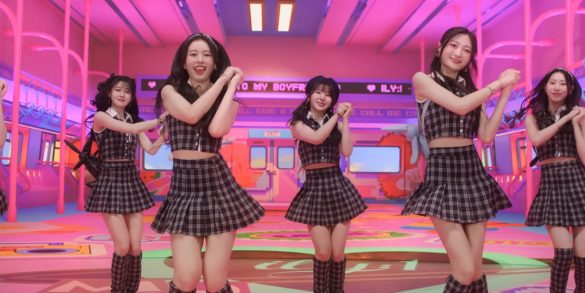 6 members of ILY:1 are dancing in a very large room that looks like a subway car.