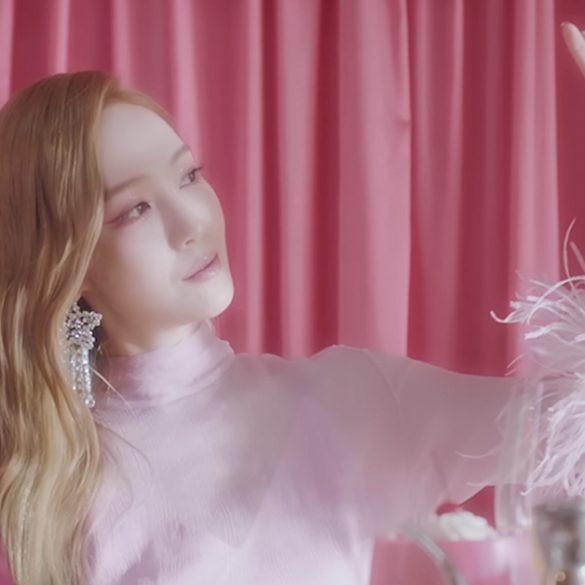 Jessica is looking at a large jewel she is holding up and away from herself