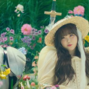 Su-hyun of AKMU sits in a field of flowers next to a knight.